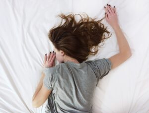 Cuscino tra le braccia per alleviare il dolore alla spalla durante il sonno sul fianco.