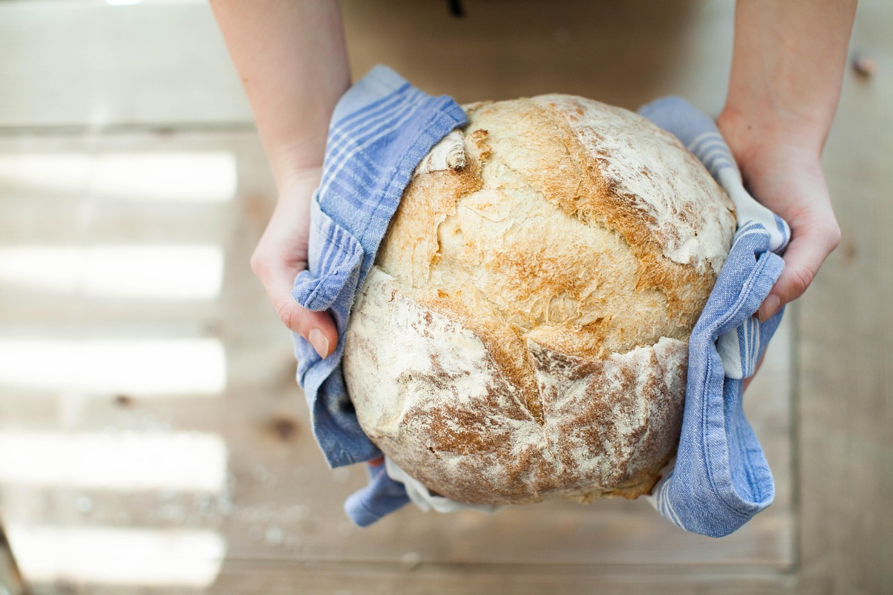 Pane fresco appena sfornato su un tavolo, simbolo di freschezza e praticità in cucina.