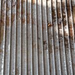 Forno sporco con incrostazioni, spruzzato con bicarbonato e acqua per la pulizia.