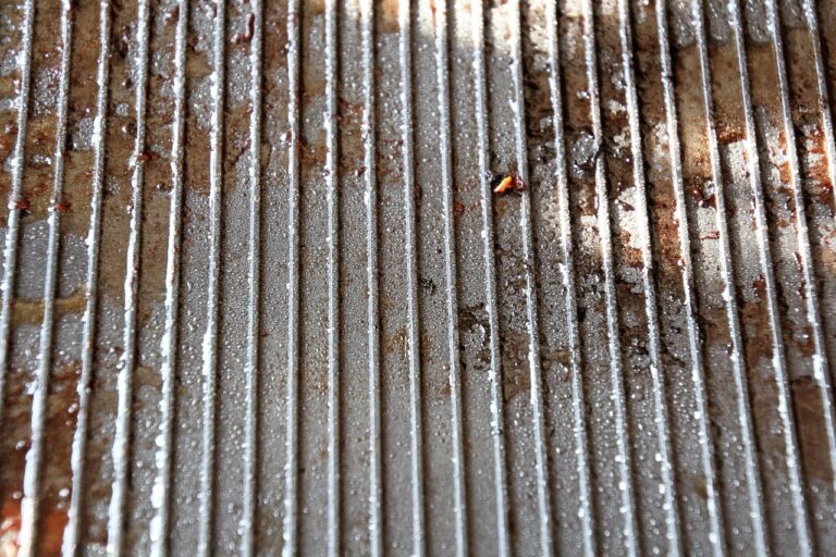 Forno sporco con incrostazioni, spruzzato con bicarbonato e acqua per la pulizia.