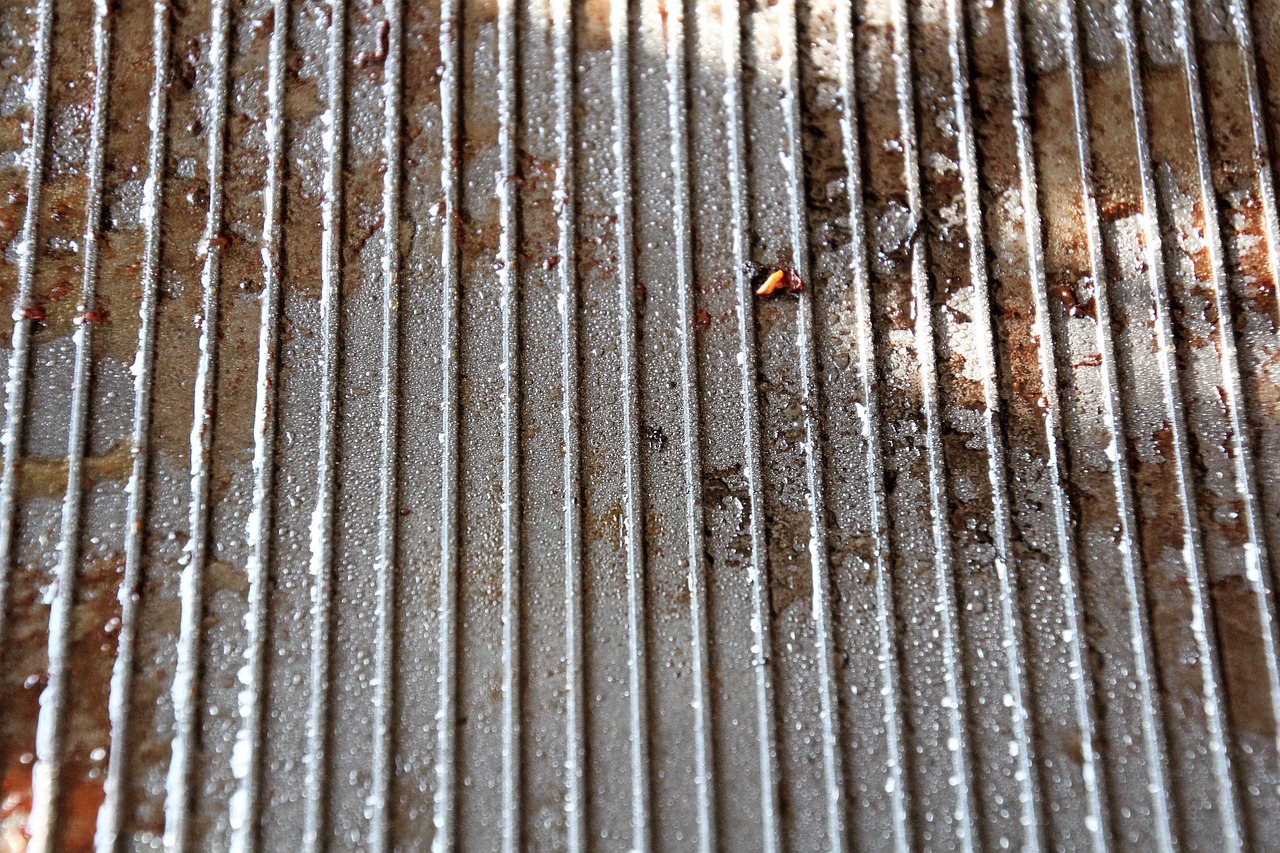 Forno sporco con incrostazioni, spruzzato con bicarbonato e acqua per la pulizia.